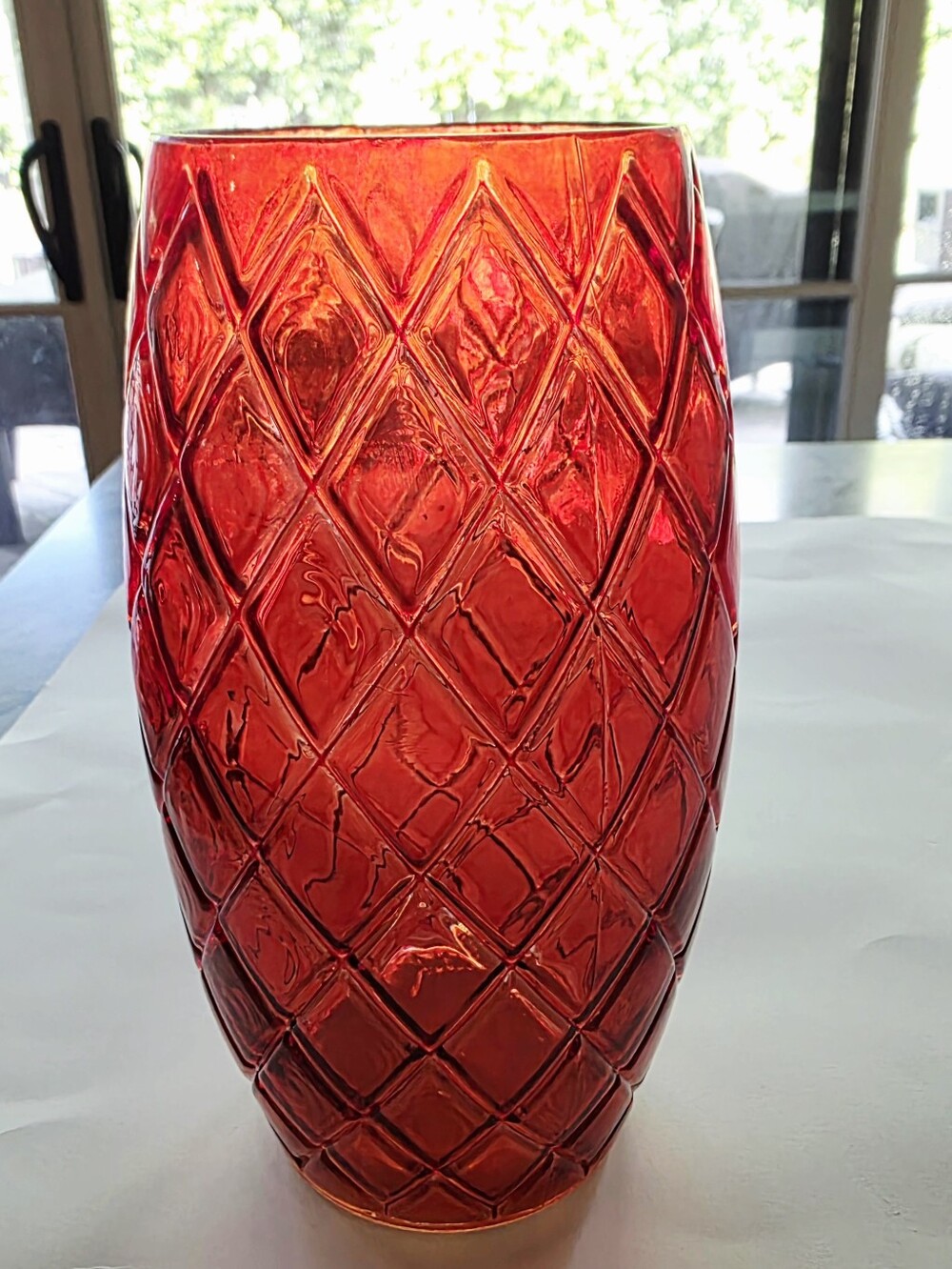 Red glass vase with a textured diamond pineapple pattern.